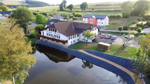 an aerial view of a house on a river at Hotel Burg Hof in Burg-Reuland