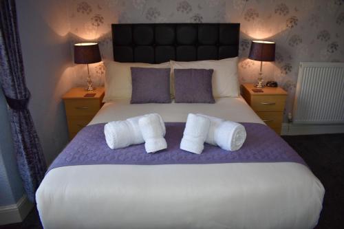 a bedroom with a large bed with two pillows at Milverton House in Llandudno