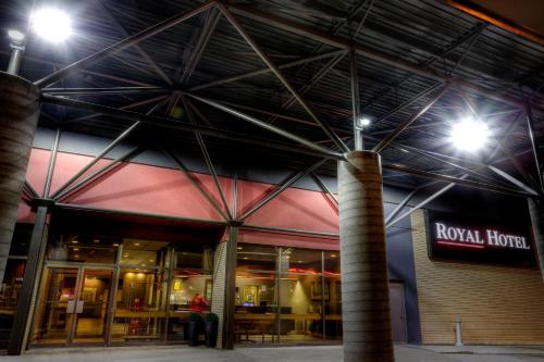 a person sitting outside of a building at night at Royal Hotel Lloydminster in Lloydminster