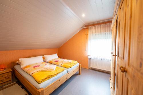 um pequeno quarto com uma cama e uma janela em Ferienwohnung Virginija em Ditscheid