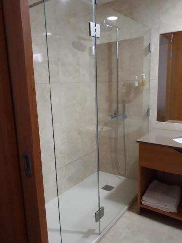 una doccia con una porta in vetro in un bagno di Angra Downtown ad Angra do Heroísmo