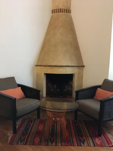 a living room with two chairs and a fireplace at Quinta Luna in Cholula