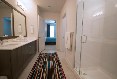 W łazience znajduje się prysznic, umywalka i lustro. w obiekcie BCA Furnished Apartments w Atlancie