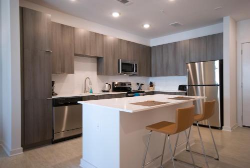 uma cozinha com armários de madeira e um balcão branco em BCA Furnished Apartments em Atlanta
