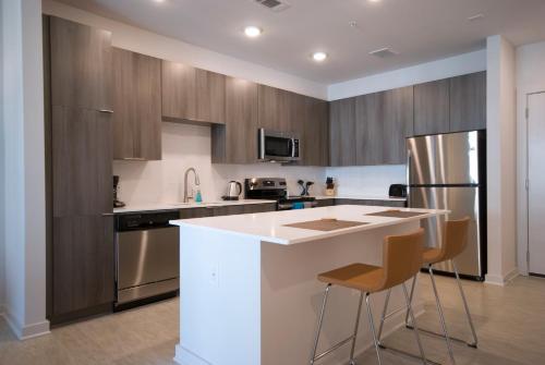 una cucina con armadi in legno e piano di lavoro bianco di BCA Furnished Apartments ad Atlanta