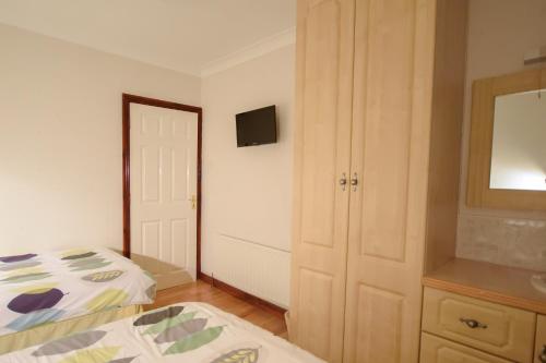 a bedroom with a bed and a tv on the wall at Rossgier Inn in Lifford