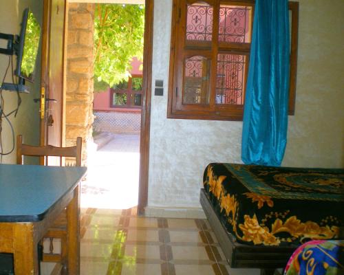 Cette chambre dispose d'une porte, d'une table et d'un lit. dans l'établissement Hotel La Gazelle, à Ouarzazate