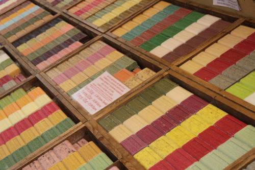 a bunch of different colored quilts on display at La Bastide de Fontaille in Saint-Félicien
