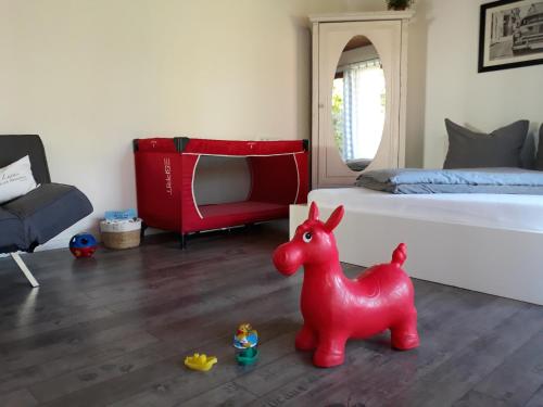 a bedroom with a red horse toy in front of a bed at Schöne EinZimmer Wohnung Zwischen Bodensee und Allgäu in Neukirch