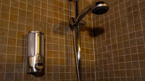 a shower in a tiled bathroom with a shower head at Posada Puerta Grande in Candelario