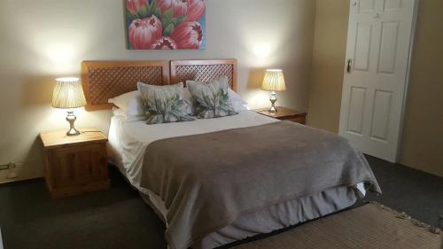 a bedroom with a large bed with two lamps at Kleines Nest Bed and Breakfast in Walvis Bay