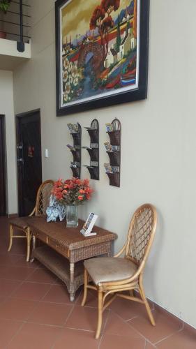 a table with two chairs and a painting on the wall at Kleines Nest Bed and Breakfast in Walvis Bay