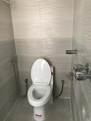 a bathroom with a white toilet in a stall at Hotel Seven Star in Dhaka