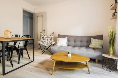 カネ・アン・ルシヨンにある"COSY" Appartement confort de 50m2 à 150m de la Mer et du Centre ville, parking gratuitのリビングルーム(ソファ、テーブル付)