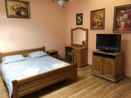 sypialnia z łóżkiem, telewizorem i lustrem w obiekcie Hotel Nikolet w mieście Mukaczewo