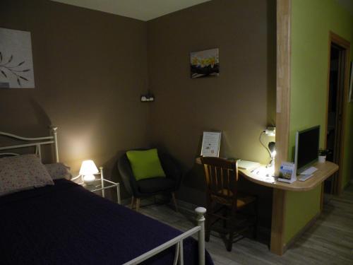 a bedroom with a bed and a desk with a computer at Les mouettes in Les Herbiers