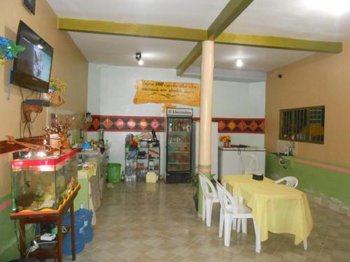 a restaurant with a table and chairs in a room at Pousada Salmo 23 in Algodoal