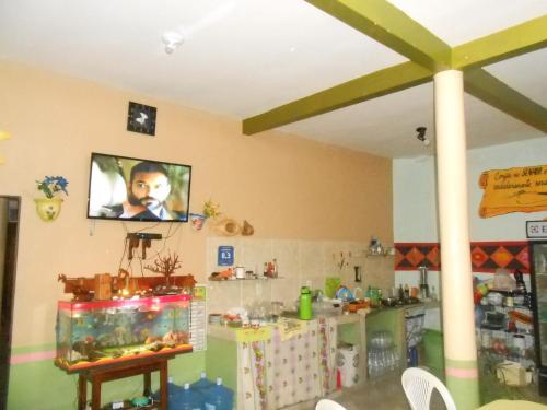 a room with a tv hanging on the wall at Pousada Salmo 23 in Algodoal