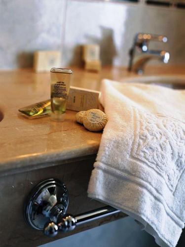 a wooden counter top with a glass and a towel at Hotel Spiaggia d'Oro - Charme & Boutique - Garda Lake Collection in Salò