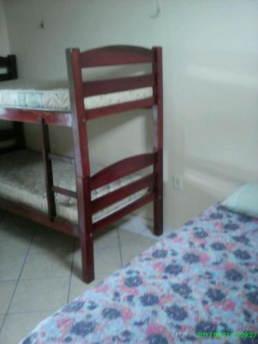 a bedroom with a bed and a wooden chair at Pousada Salmo 23 in Algodoal