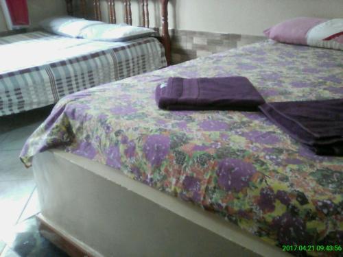 a bed with a blanket on it in a room at Pousada Salmo 23 in Algodoal