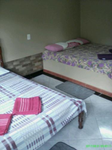 two twin beds in a room with two mattresses at Pousada Salmo 23 in Algodoal