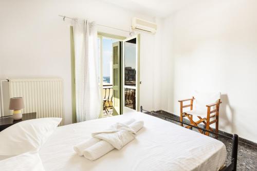ein weißes Schlafzimmer mit einem Bett mit Handtüchern darauf in der Unterkunft Sea View Penthouse with Roof Garden in Chania