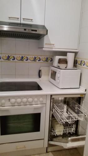 een keuken met een wit fornuis en een magnetron bij Jaca Centrum in Jaca