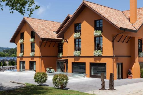 a large orange building with plants on the windows at Hotel The Park Derio in Derio