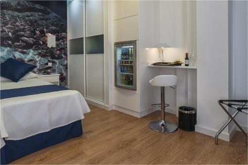 a hotel room with a bed and a drink refrigerator at Hotel Ciudad del Mar in Las Palmas de Gran Canaria
