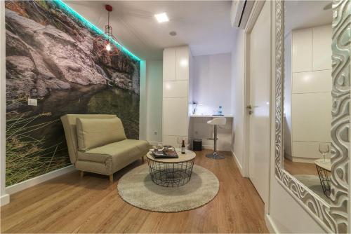 a living room with a chair and a table at Hotel Ciudad del Mar in Las Palmas de Gran Canaria