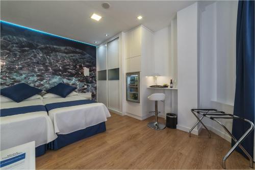 a bedroom with a bed with a painting on the wall at Hotel Ciudad del Mar in Las Palmas de Gran Canaria