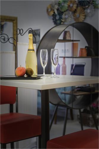 a table with two wine glasses and a bottle on it at Hotel Ciudad del Mar in Las Palmas de Gran Canaria
