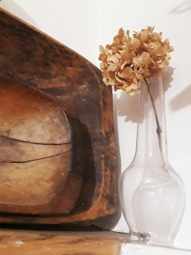 a vase with a flower in it next to a painting at Pension Laura in Chřibská