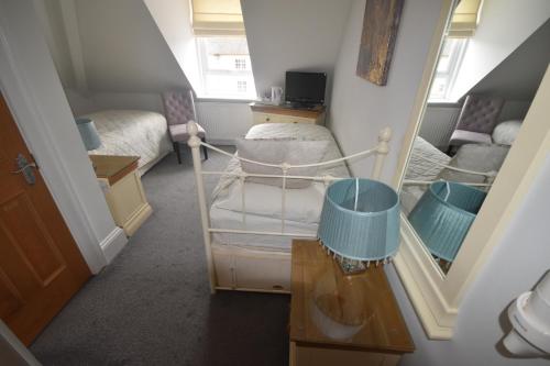 a small room with two beds and a mirror at Gordon House in Wimborne Minster