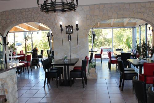 a restaurant with tables and chairs and windows at Hotel zum Goldenen Wagen in Maulburg
