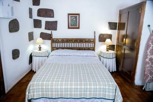 テヘーダにあるCasa Servandoのベッドルーム1室(ベッド1台、ランプ2つ、テーブル2台付)