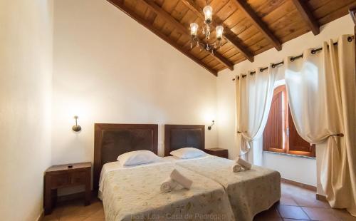 a bedroom with a bed and a chandelier at Casa de Pedrógão in Pedrógão