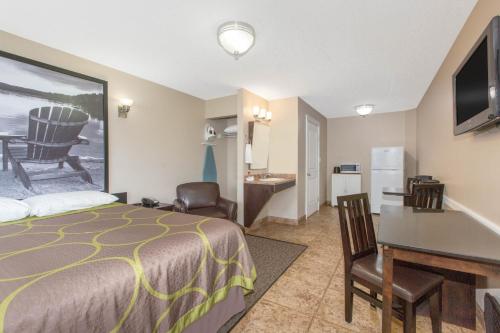 a hotel room with a bed and a desk at Super 8 by Wyndham Fort McMurray in Fort McMurray