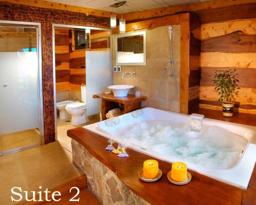 een groot bad in een badkamer met een toilet bij Suites de la Colina in La Cumbrecita