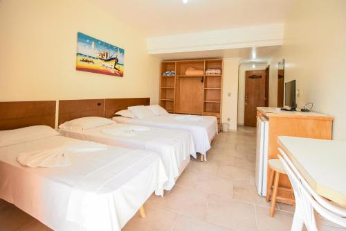 a room with two beds and a tv in it at Pousada Lugar ao Sol in Bombinhas