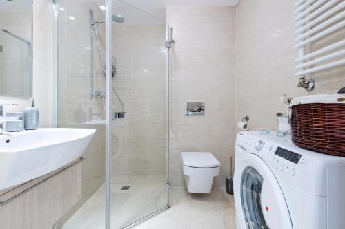 Un baño con lavadora y lavabo. en Kopernika8 Miro Apartment with Balcony and AC, en Cracovia