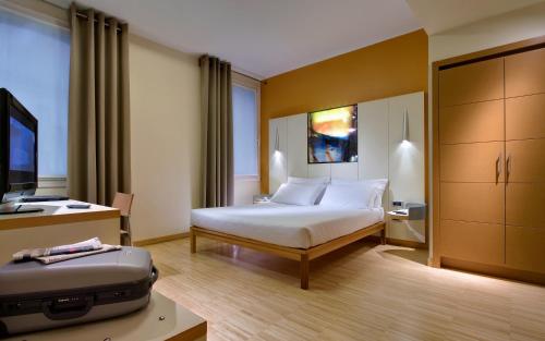 a hotel room with a bed and a suitcase at Best Western Plus Hotel Bologna in Mestre