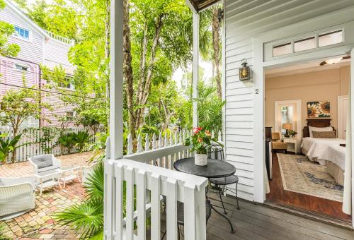a porch with a table and a bed on a house at Old Town Manor in Key West