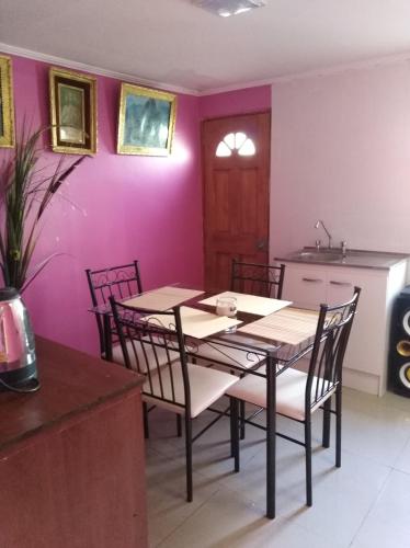 uma sala de jantar com paredes roxas e uma mesa e cadeiras em Jallalla em Calama