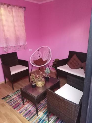 salon z różowymi ścianami i krzesłami oraz stołem w obiekcie Jallalla w mieście Calama