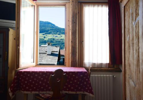een kamer met een tafel en een raam met uitzicht bij premesan in Bormio