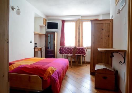 een slaapkamer met een bed, een tafel en een raam bij premesan in Bormio