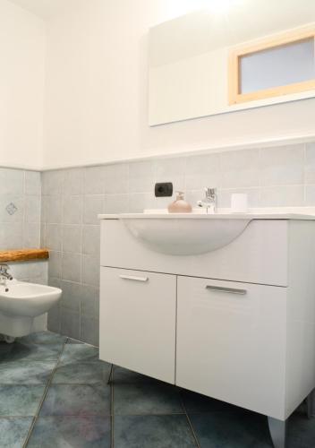 a white bathroom with a sink and a toilet at premesan in Bormio