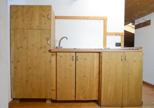 a kitchen with wooden cabinets and a sink at premesan2 in Bormio